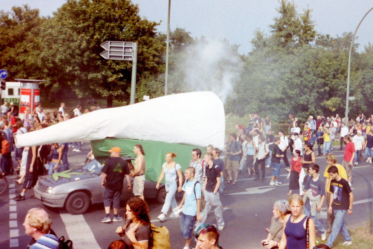 Archivfoto: Paradewagen auf der Hanfparade 2002 (von Nicole auf der Mauer) Paradewagen auf der Hanfparade 2002 - PKW mit rauchendem Riesenjoint auf dem Dach