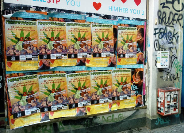 Foto von Hanfparade Postern geklebt an einer Wand, irgendwo draussen